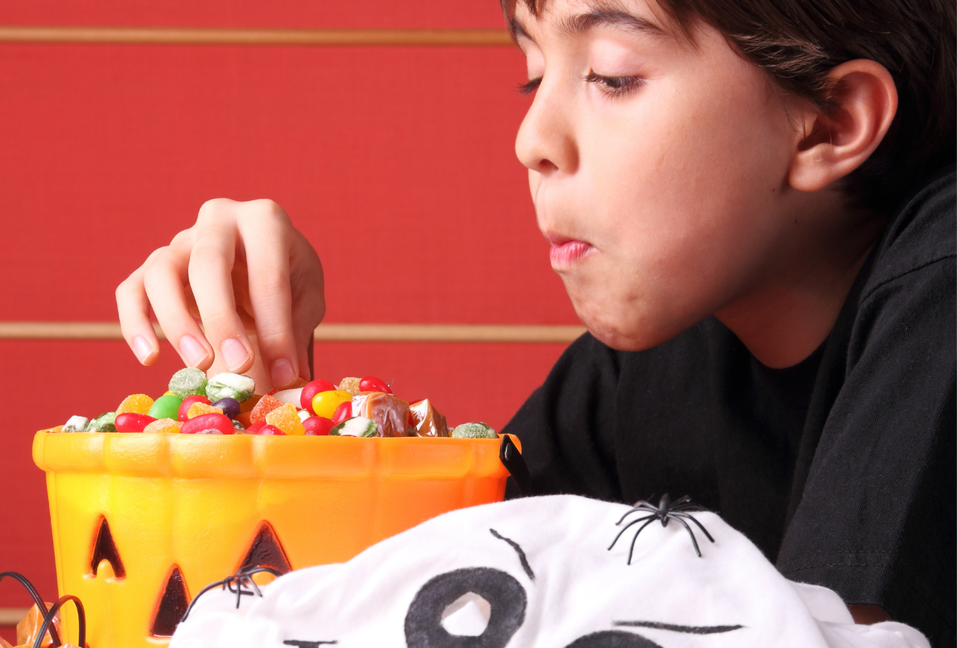 dark haired boy eating halloween candy