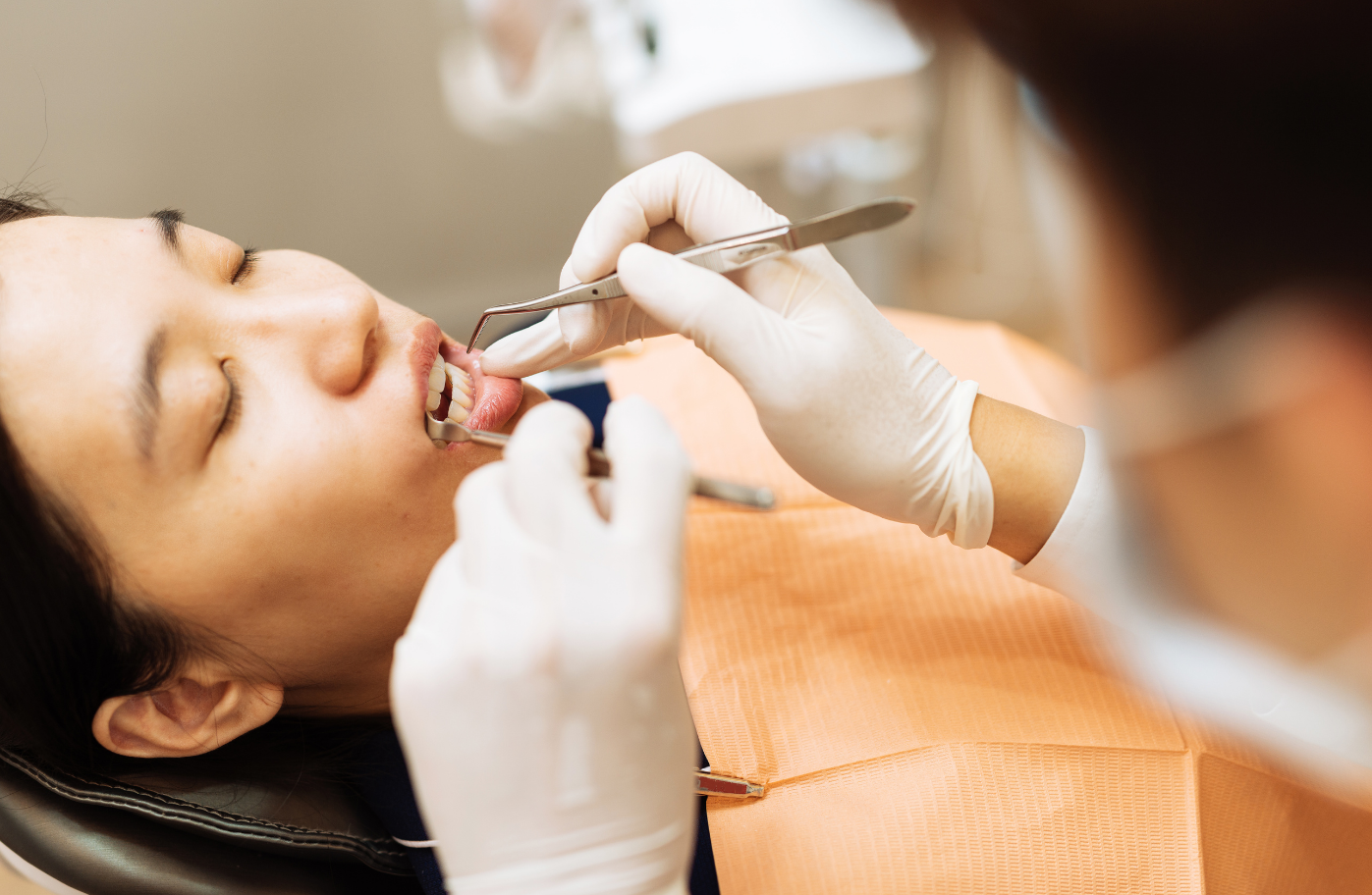 dental hygienist scaling patients teeth to remove tartar