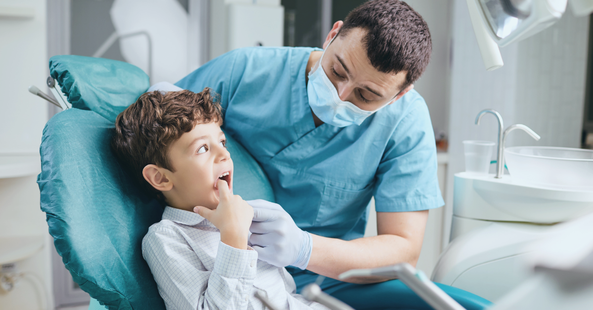 child in dentists chair being talked to by dentist at Saskatoon Dental Group Canadian Dental Plan Care Plan what do you need to know